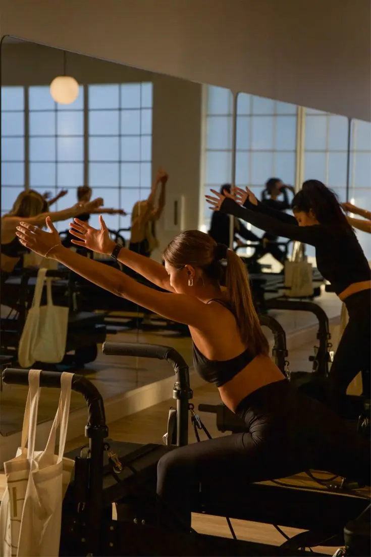 Warm reformer class in a softly lit studio